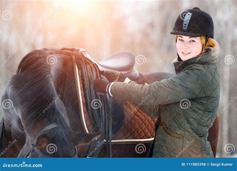 Young Woman Adjusting Stirrups before Riding Horse Stock Photo - Image ...