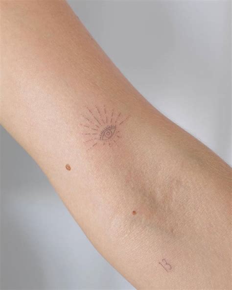 Fine line style evil eye and number "13" tattoos