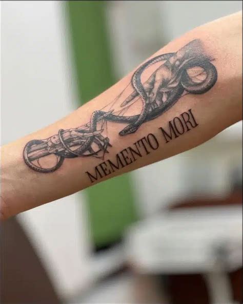 a tattoo with an octopus on the arm that says mementoo mori in black ink