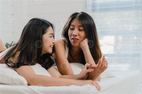 Asian Lesbian lgbtq women couple kiss and hug on bed at home. Young