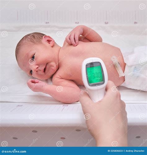 A Mother Measures The Temperature Of Her Daughter Stock Photo