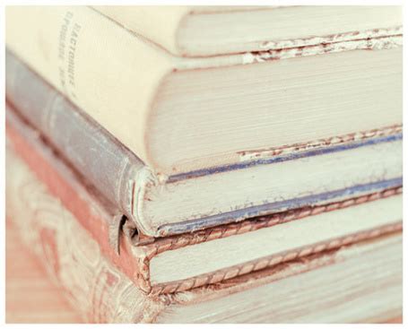 Фото Стопка старых книг на комоде с улиткой и вырванными листами