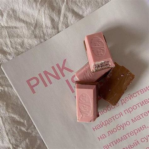 three pieces of pink chocolate sitting on top of a piece of paper