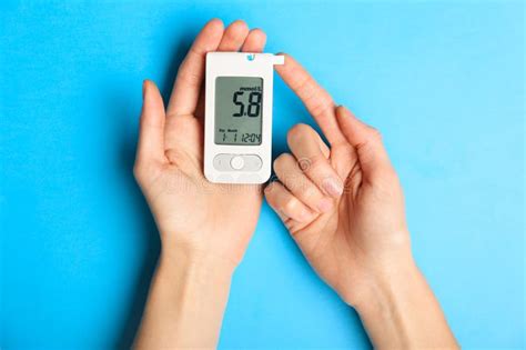 Hands of Diabetic Woman with Digital Glucometer on Color Background ...