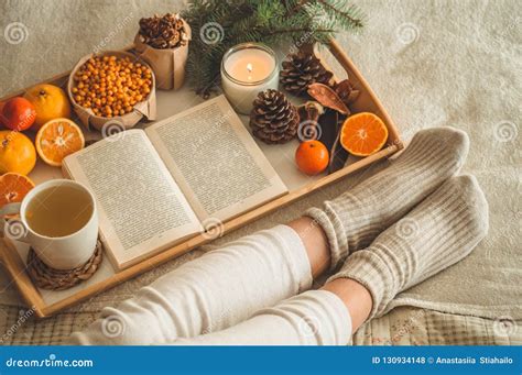 Уютный вечер зимы, теплые шерстяные носки Женщина лежа ноги вверх на ...