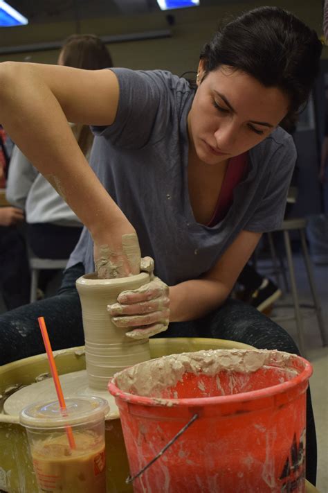 Senior Ava Dank shapes her cylinder on the wheel. Photo by Audrey
