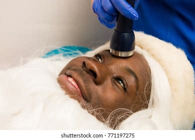 santa claus receiving facial beauty treatment stock photo