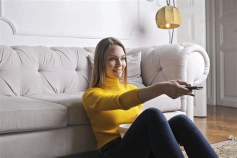 Happy young relaxed woman watching TV at home · Free Stock Photo