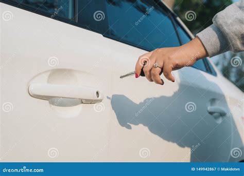 Женщина с ключом автомобиля Раскрывая автомобильная дверь Рука женщины ...