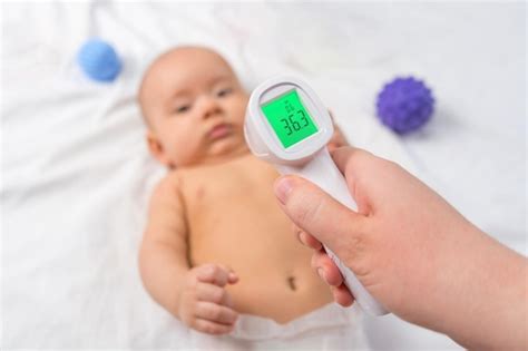 Termometro Para Recem Nascido - O médico mede a temperatura do recém-nascido com um termômetro ...