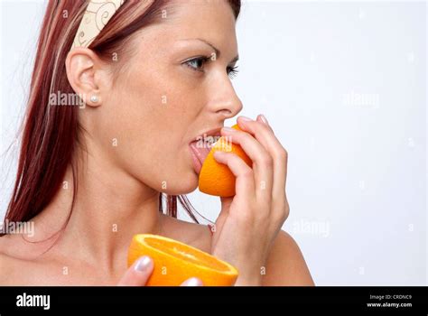 young woman licking at an orange Stock Photo - Alamy