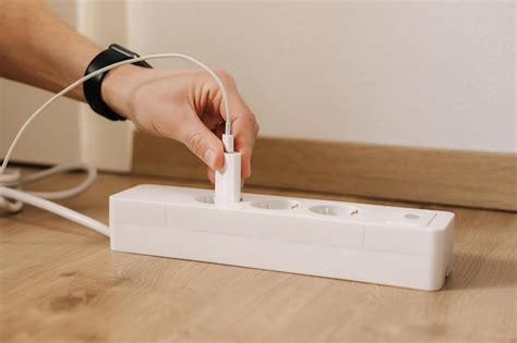 Premium Photo | A person plugs into a power strip.