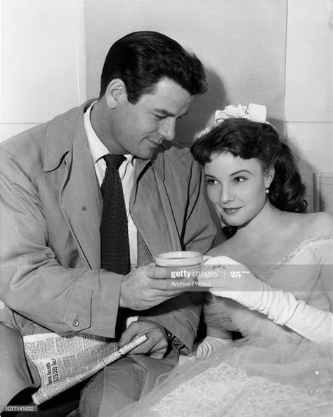 American actor Gig Young brings co-star Janice Rule a cup of coffee