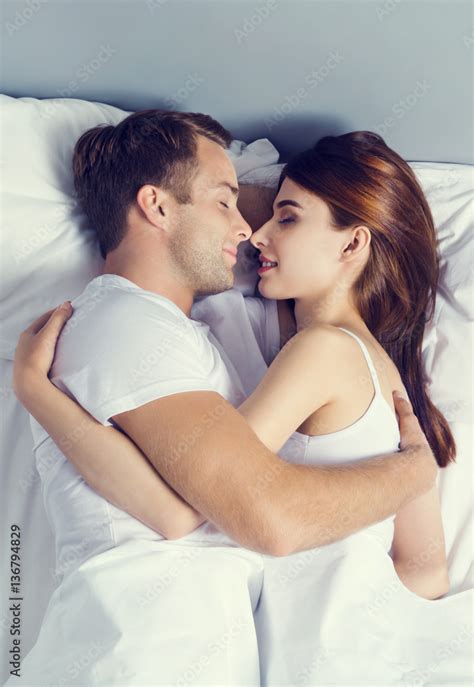 Young couple sleeping and hugging on the bed in bedroom Stock Photo ...