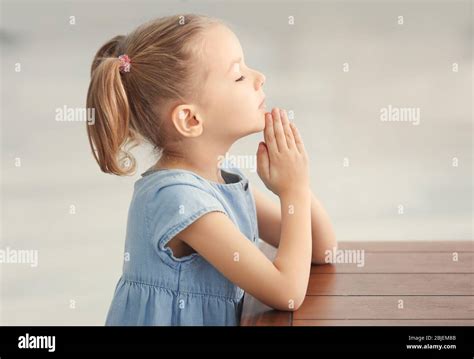 Cute little girl praying at home Stock Photo - Alamy