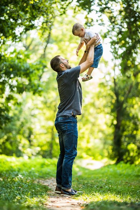 Premium Photo | Dad and son having fun in park in summer day