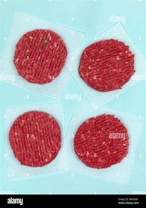 Burger patties isolated on a pale blue background Stock Photo - Alamy