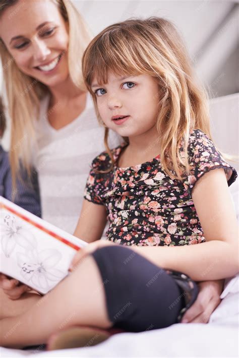 Premium Photo | Reading mother and daughter on sofa with book for