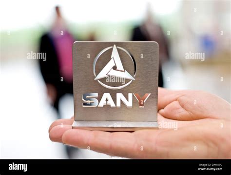 A SANY Group employee holds the company's logo at a production site in ...