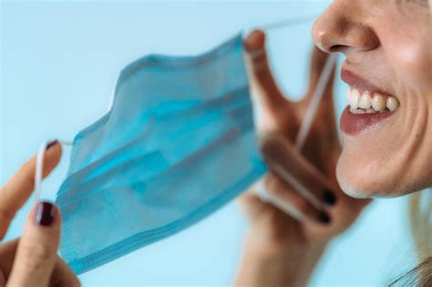 Premium Photo | Smiling woman taking off face mask