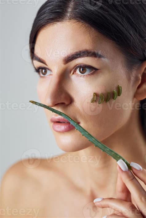 Naked woman is in the studio against white background with aloe vera