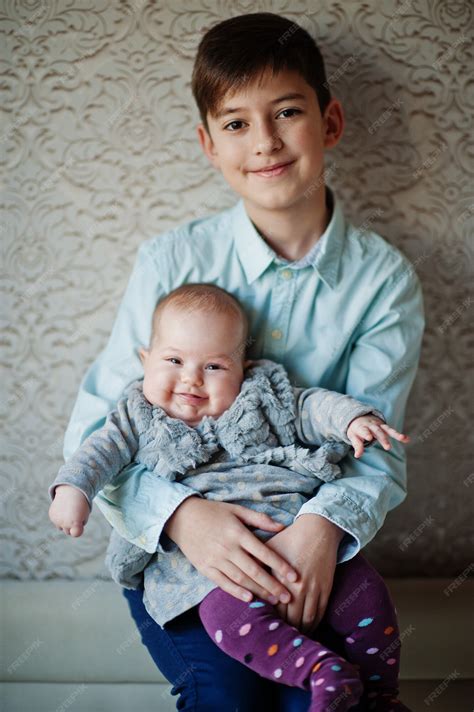 Hermano mayor con hermana menor en manos. | Foto Premium