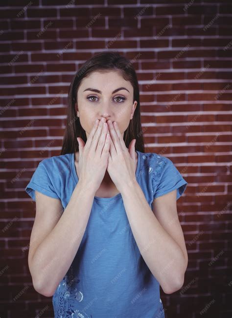 Premium Photo | Pretty brunette with hands over mouth