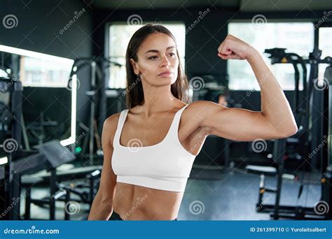 Athletic Woman Looking at the Muscles on Her Arm. Stock Photo - Image ...