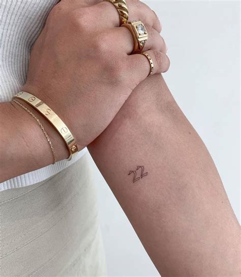 "22" lettering tattoo on the inner