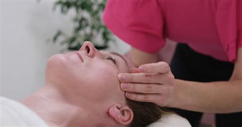 Close-up of professional massage of face, temples and ears, woman