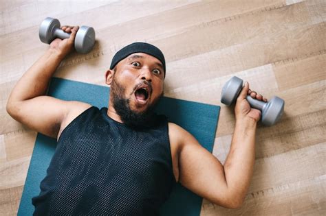 Premium Photo | Funny fat man doing exercises with dumbbells on a ...