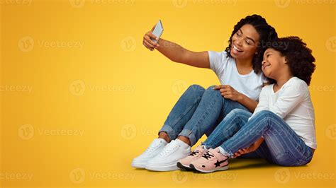 Family Selfie. Cheerful black mother taking photo with her little cute