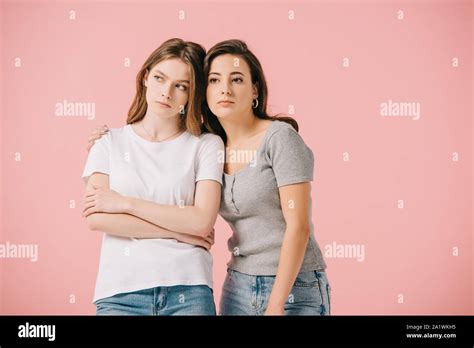 attractive woman hugging her sad friend isolated on pink Stock Photo ...