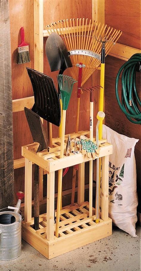 a wooden rack holding gardening tools in front of a wall