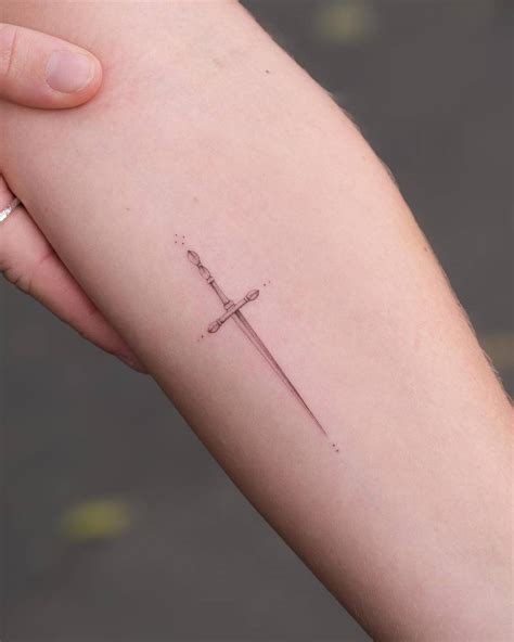 Single needle sword tattoo done on the inner forearm.