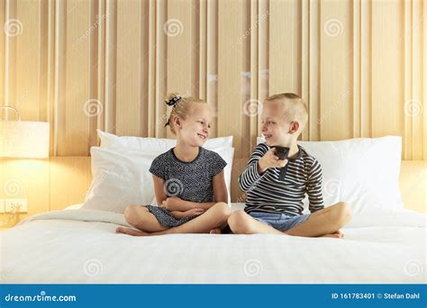 Smiling Little Brother and Sister Changing Channels while Watchi Stock 