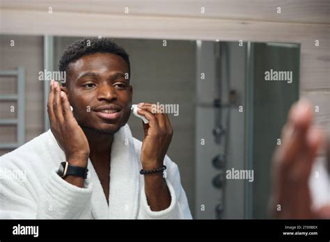 young guy applies shaving foam   face stock photo alamy