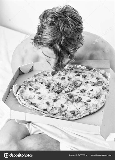 Man bearded handsome guy eating cheesy food for breakfast in bed