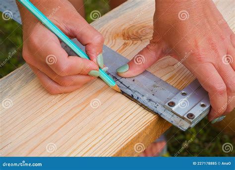 Woman Carpenter Makes Pencil Markings on a Wooden Board. DIY in the ...