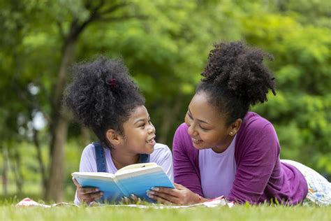 African American mother is teaching her young daughter to read while