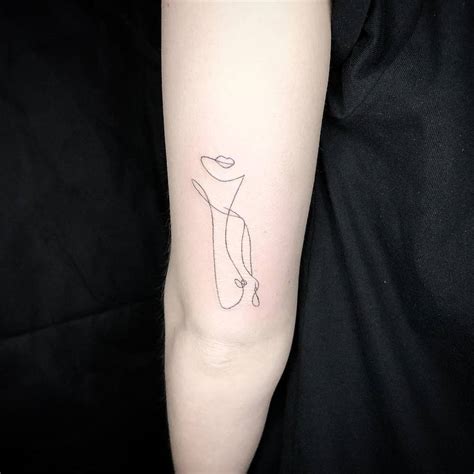 Single line nude woman tattoo on the tricep.