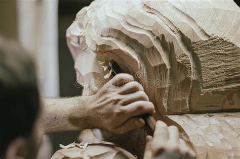 sculptor carving wooden statue  chisel  workshop stock image