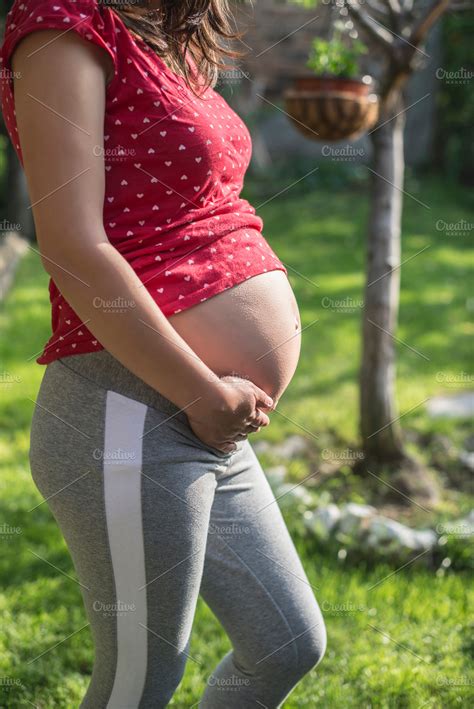 Pregnant woman shows his belly in t containing pregnant, woman, and