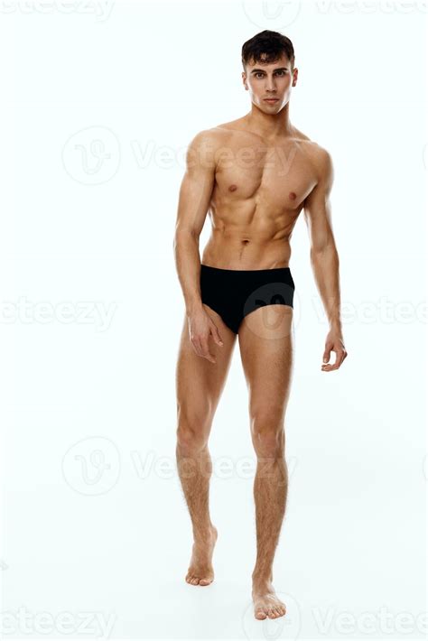 naked man athlete in full growth on a light background black panties