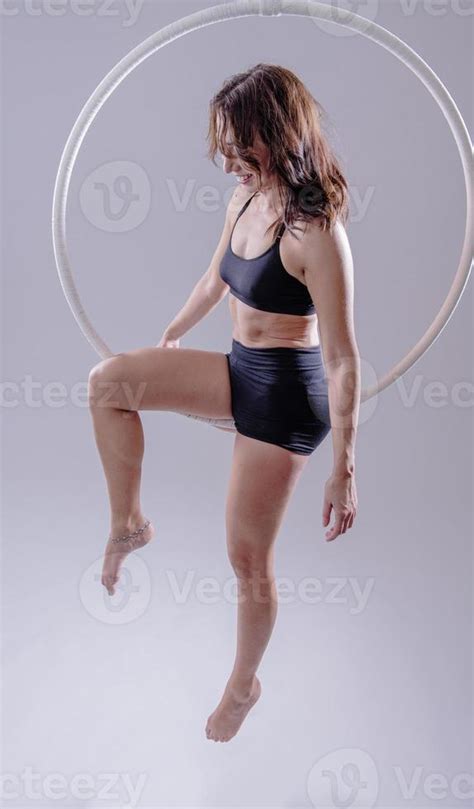 A female Aerial hoop gymnast performing exercises on an Aerial hoop ...