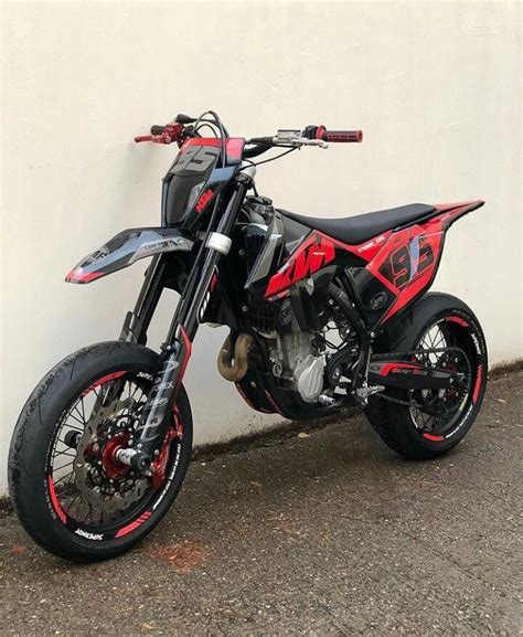 Red and Black Dirt Bike Parked Next to Graffiti Wall