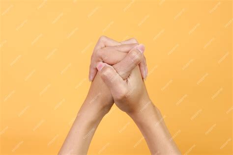 premium photo hands clasped    prayer isolated  yellow