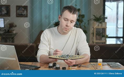 Man Paints the Layout Elements with Brush and Looks at Instructions on ...