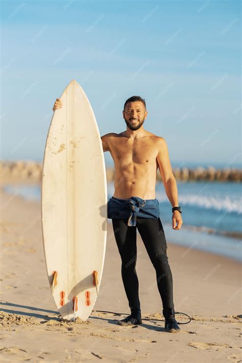 Premium Photo | Smiling man surfer with naked torso standing on the