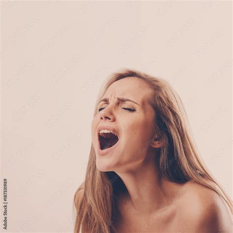 portrait of a young woman during an orgasm on a white background Stock